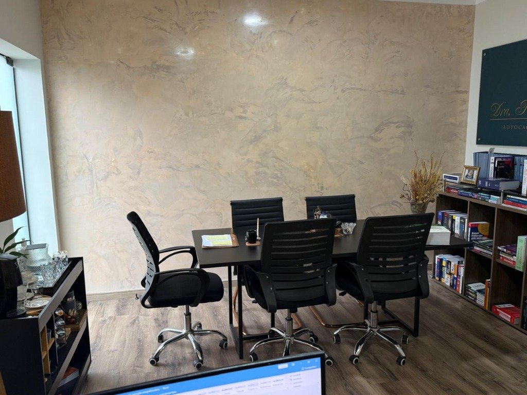 Sala de atendimento e reuniões com mesa executiva e placa institucional da Dra. Kelli Lima